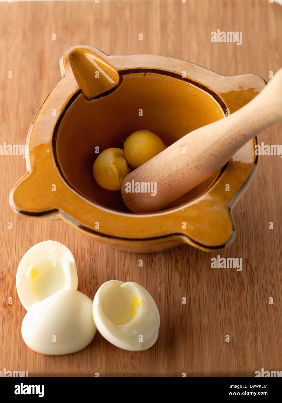 Das hartgekochte Eigelb in einem Mörser zerkleinern Stockfoto