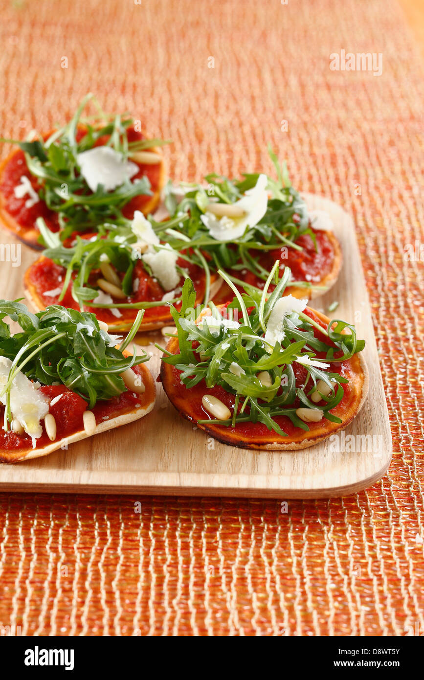 Rucola Salat und Confit Tomate Mini Pizzen Stockfoto
