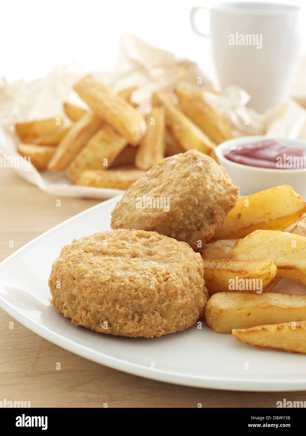 Bier zerschlagen grüne Fischfrikadellen Chips Tomaten Sauce Tasse Tee Teller Tisch Stockfoto