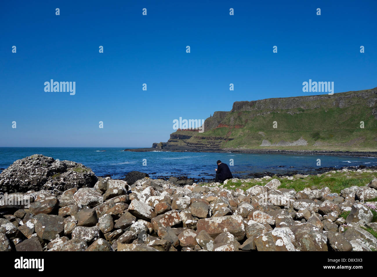 orientalische Geschäftsmann im Anzug sitzt überprüft e-Mails an Giants causeway Stockfoto