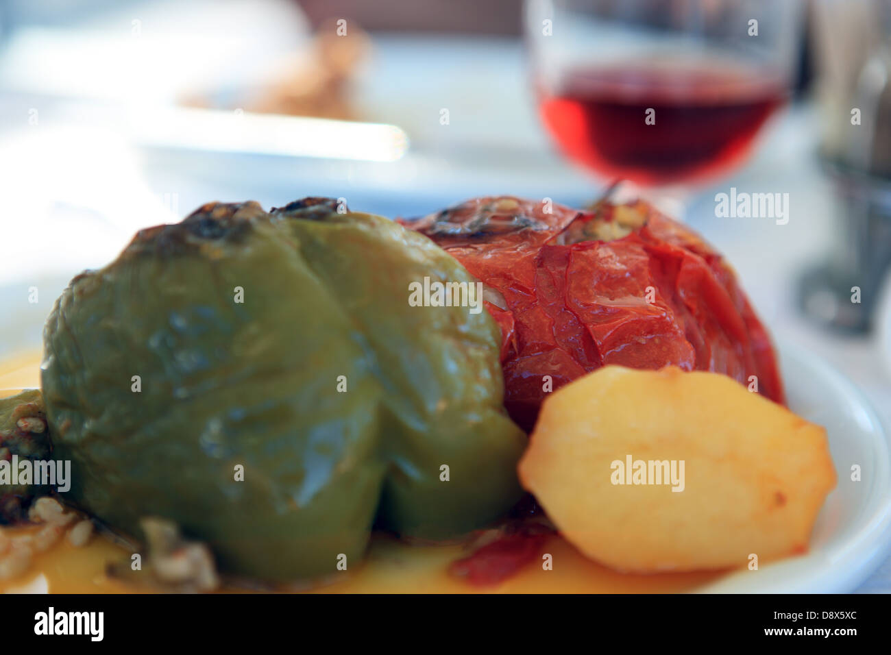 Gefüllte Paprika und einem Glas Rot-weiß auf einem Tisch im Rahmen einer griechischen Mahlzeit Stockfoto