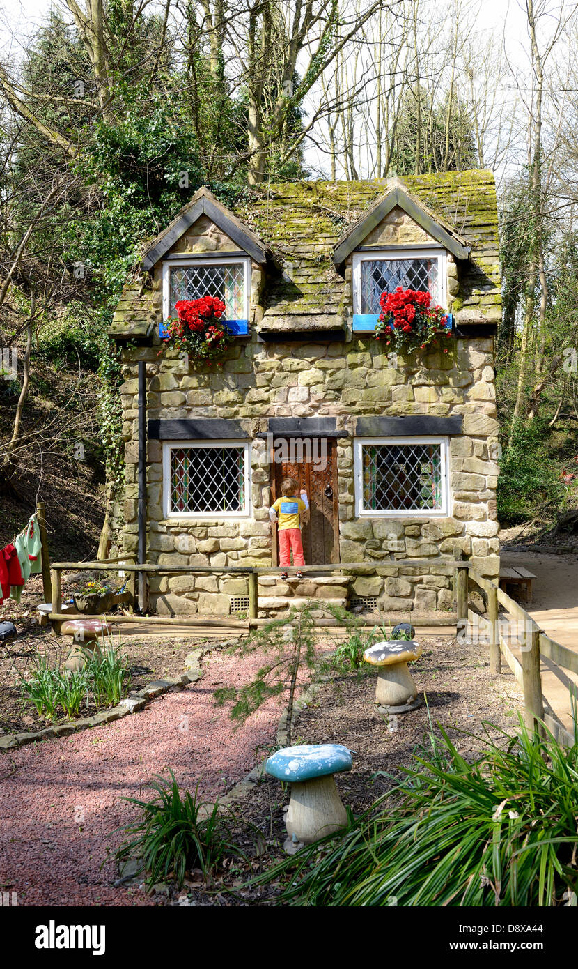 kleiner Junge klopft an einem Märchen-Haus im Wunderland. Stockfoto