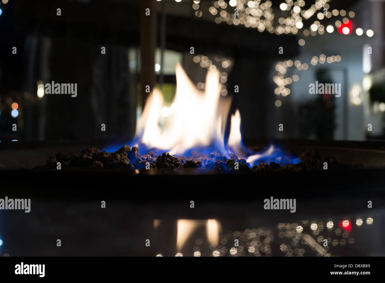 Blaue Flammen brennen über Kohlen vor der weißen Leuchten Stockfoto