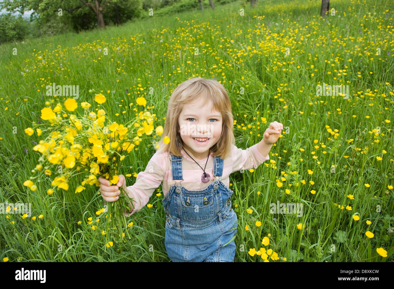 Vier Jahre altes Mädchen mit einem Blumenstrauß auf einer Wiese im Frühling Stockfoto