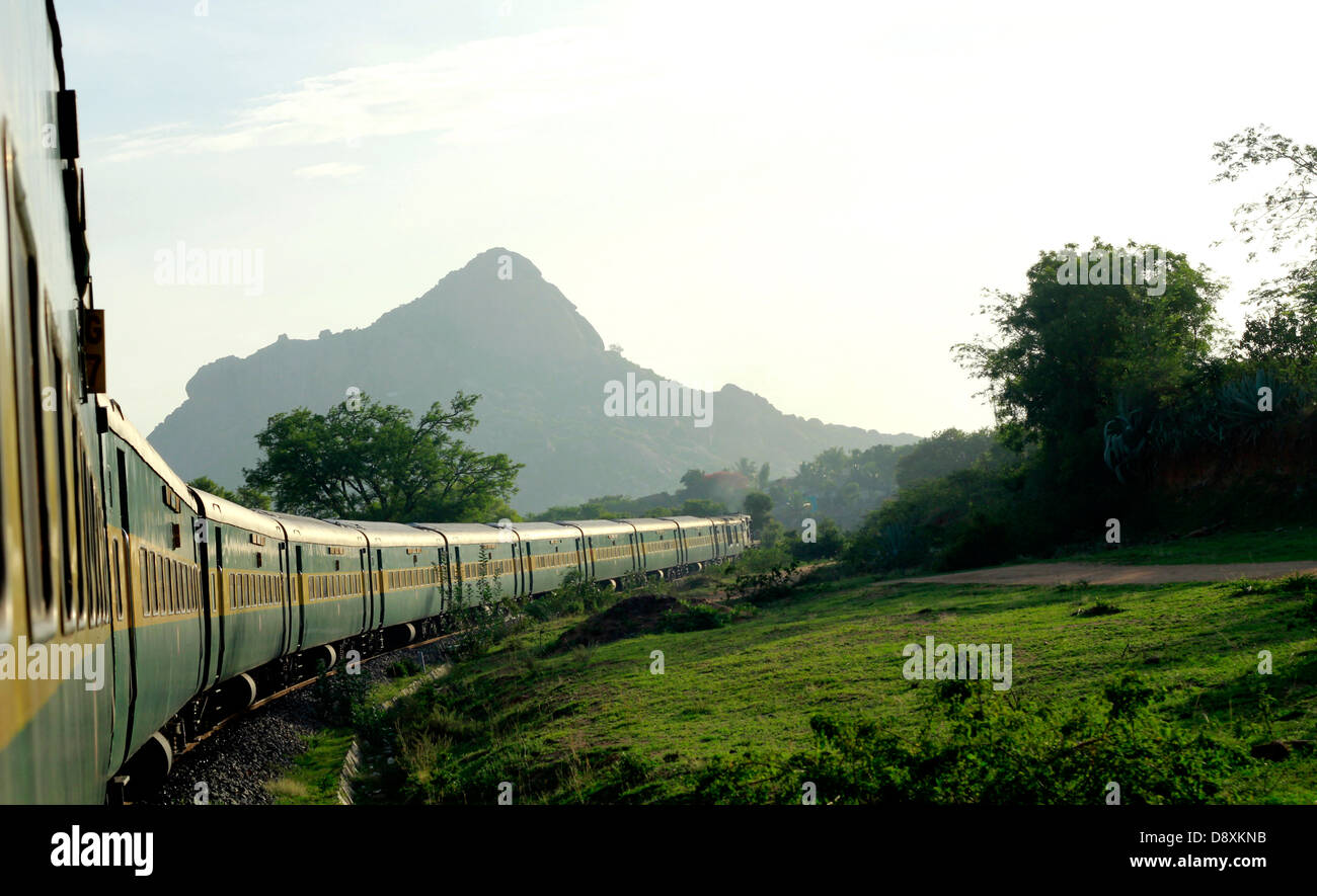 Eine indische Eisenbahn Zug (Garib Rath) Manöver eine Kurve in den Western Ghats; Tamil Nadu, Indien. Stockfoto