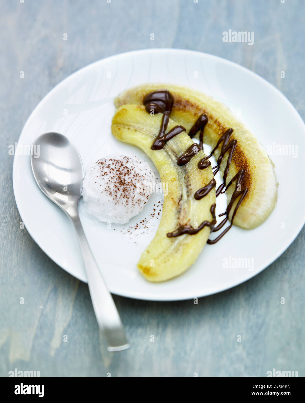 Gebratene Bananen mit Schokosauce, Schlagsahne Petit-Suisse mit Kakao Stockfoto