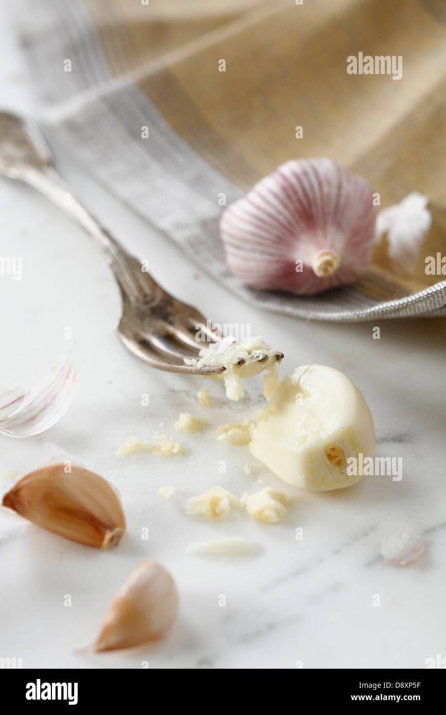 Mit einer Gabel Nelken Knoblauch zerkleinern Stockfoto