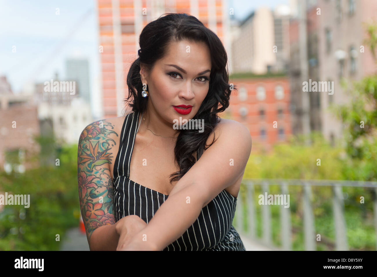 Attraktive Brünette mit tätowierten Arm auf High Line, New York Stockfoto