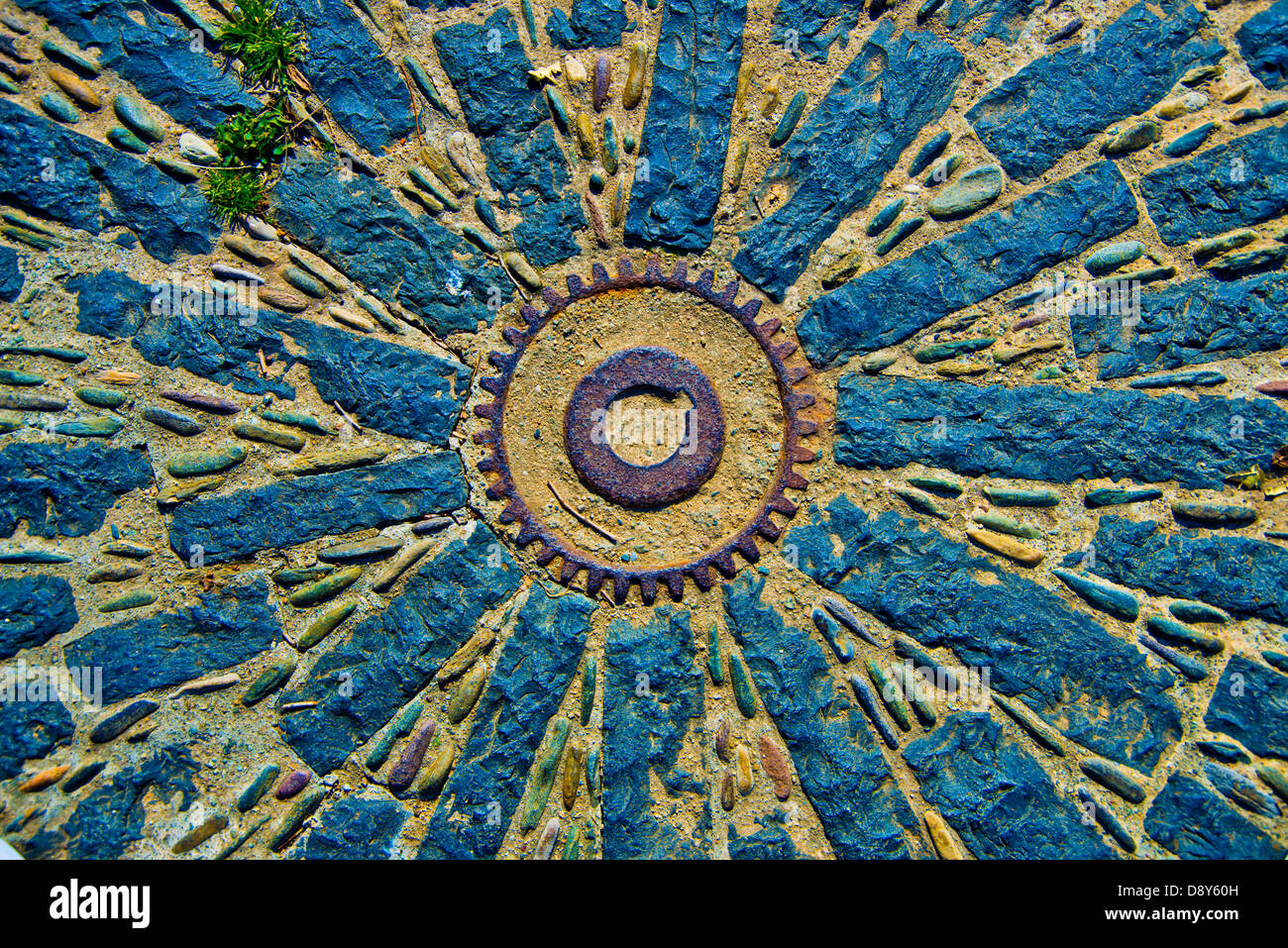 Kunstwerke aus Stein, rostige Zahnrad auf dem Boden. Kunst-Hintergrund Stockfoto