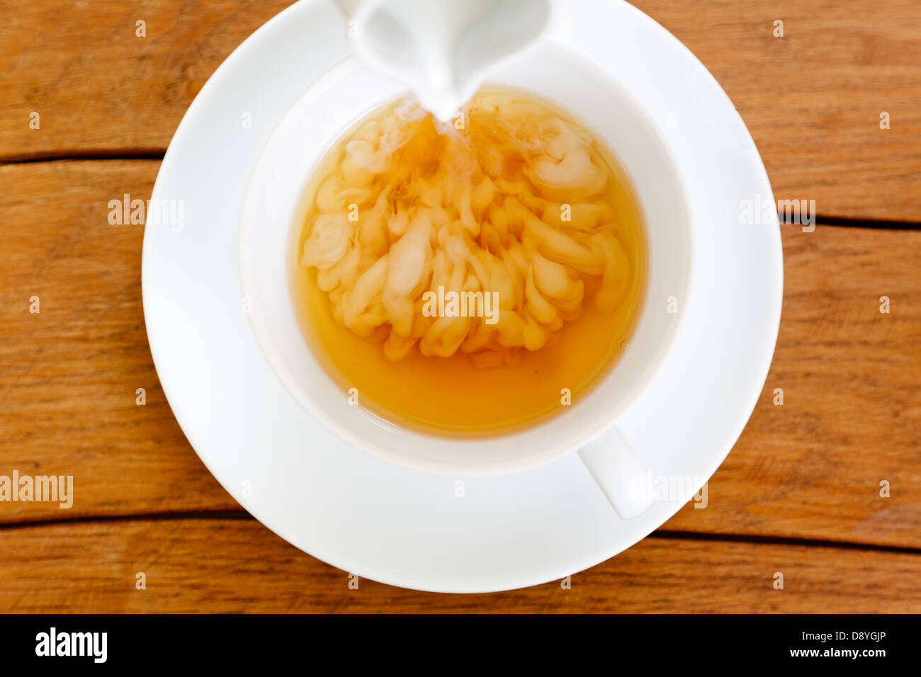 Tasse Tee mit Milch und Teekanne Stockfoto