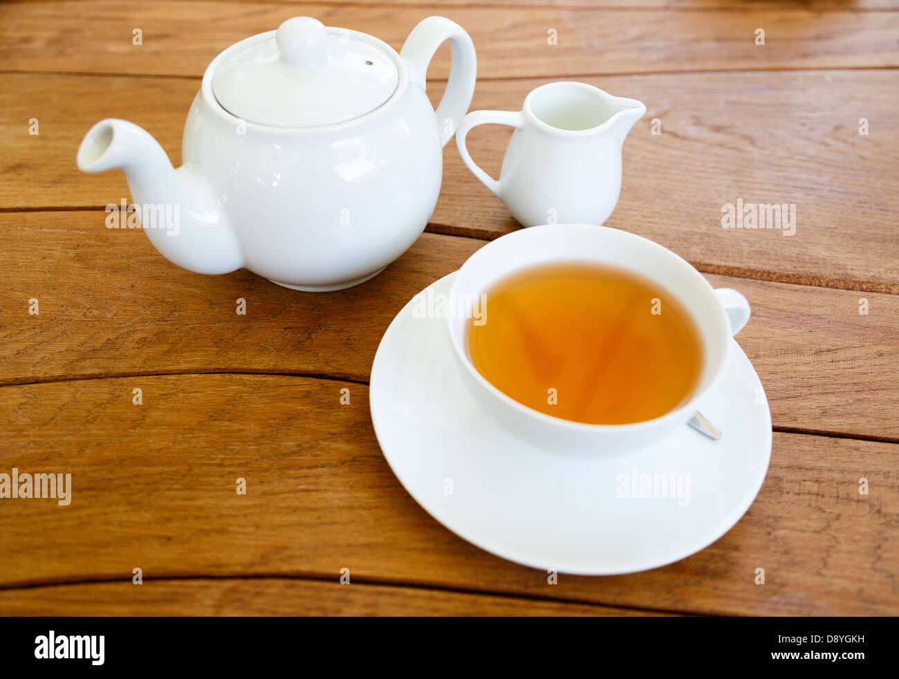Tasse Tee mit Milch und Teekanne Stockfoto