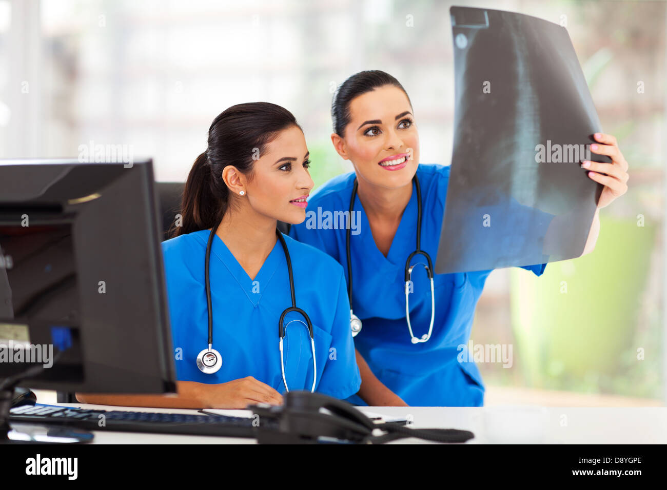 zwei moderne medizinische Arbeitnehmerinnen Studium des Patienten X-Ray im Büro Stockfoto