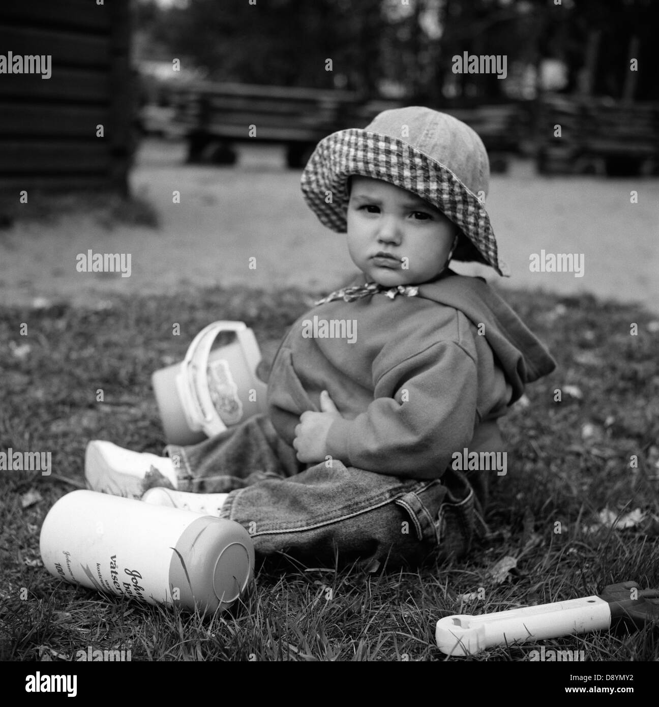 Baby auf dem Rasen sitzen und spielen Stockfoto