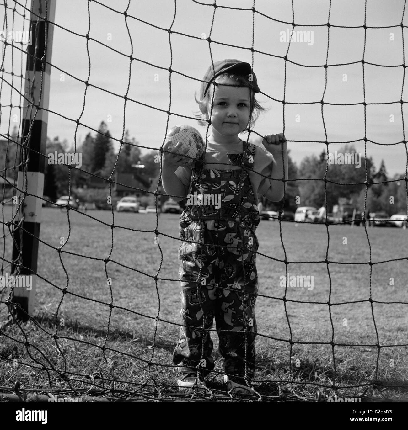 Jungen suchen durch Netz auf Fußballplatz Stockfoto