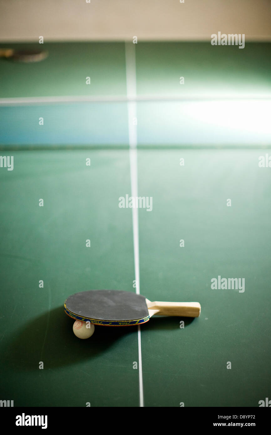 Tischtennisschläger mit Ball auf Tisch Stockfoto