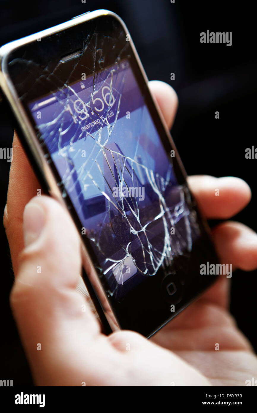 Person halten Handys mit gebrochenen Bildschirm Stockfoto