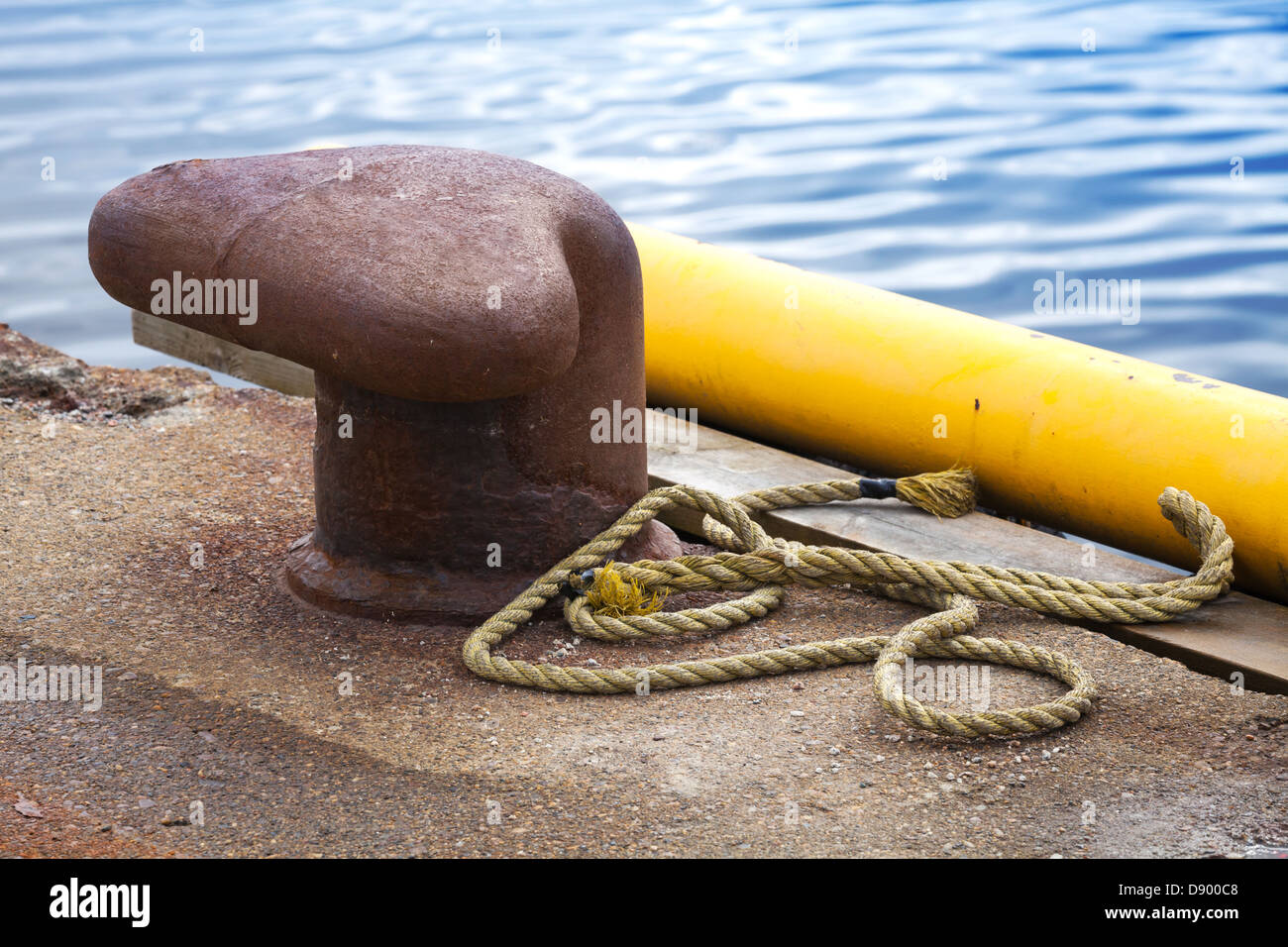 Alte verrostete Liegeplatz Poller mit Marine Seil auf Betonpfeiler Stockfoto