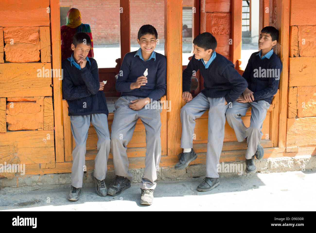 Eine Gruppe von Gymnasiasten essen Eis vor Klassen in den Himalaya Stadt Bharmour, Himachal Pradesh, Indien Stockfoto