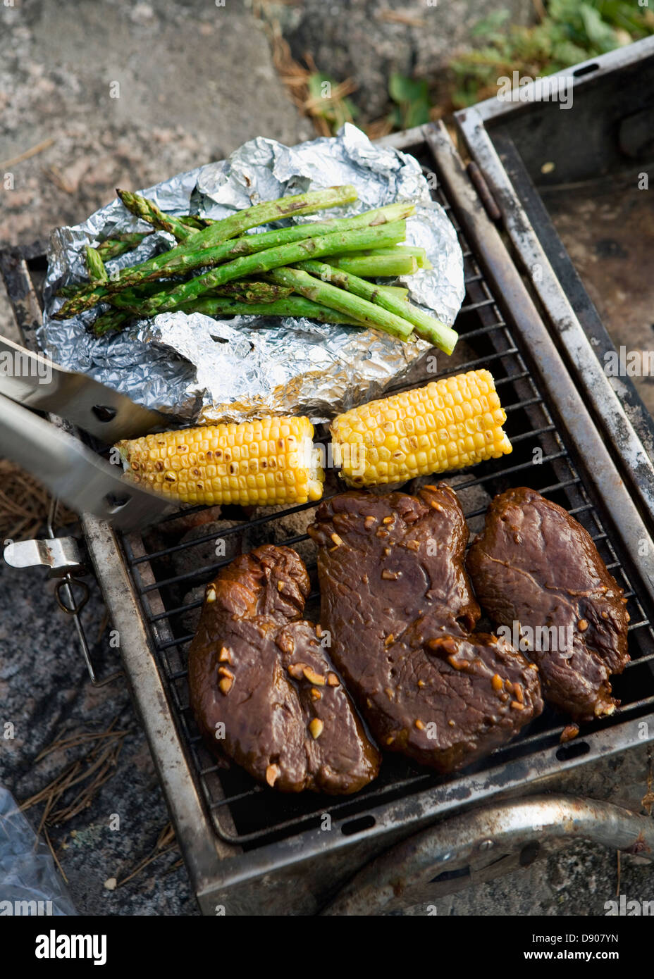 Grillen mit Fleisch, Maiskolben und Spargel. Stockfoto