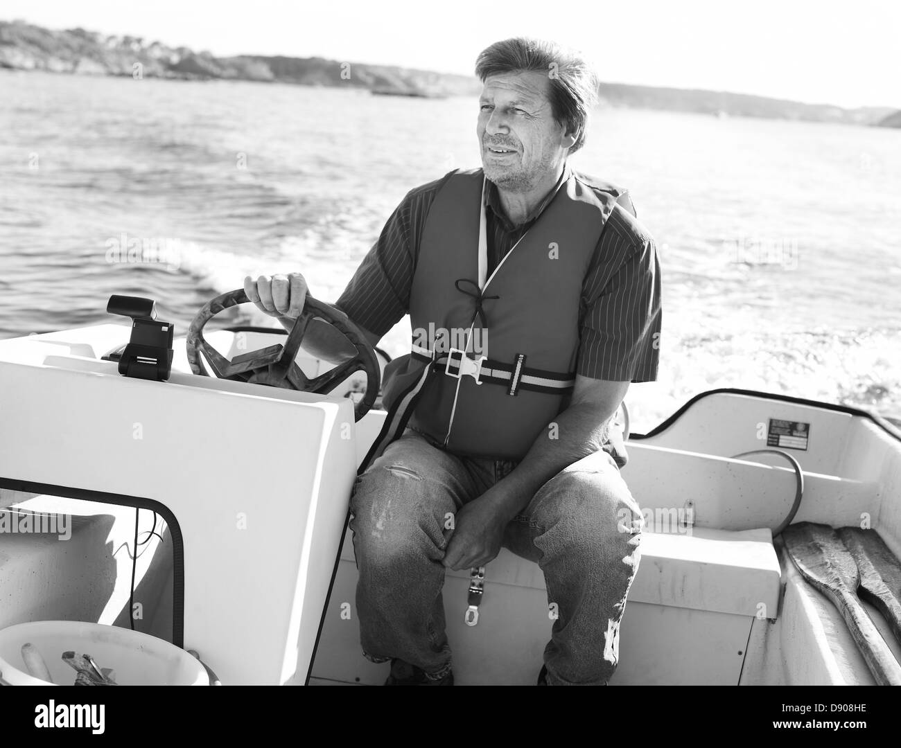 Ältere Mann fahren ein Motorboot, Schweden. Stockfoto