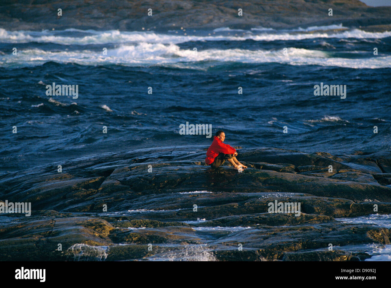 Ein Mann sitzt auf einer kleinen Insel. Stockfoto