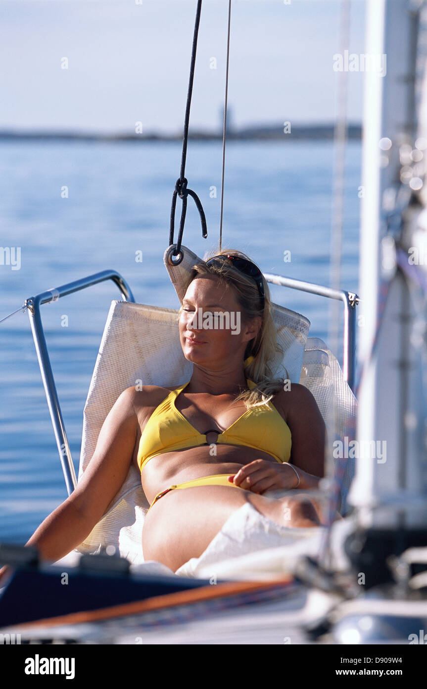 Frau in einer Hängematte auf einem Boot, Schweden. Stockfoto