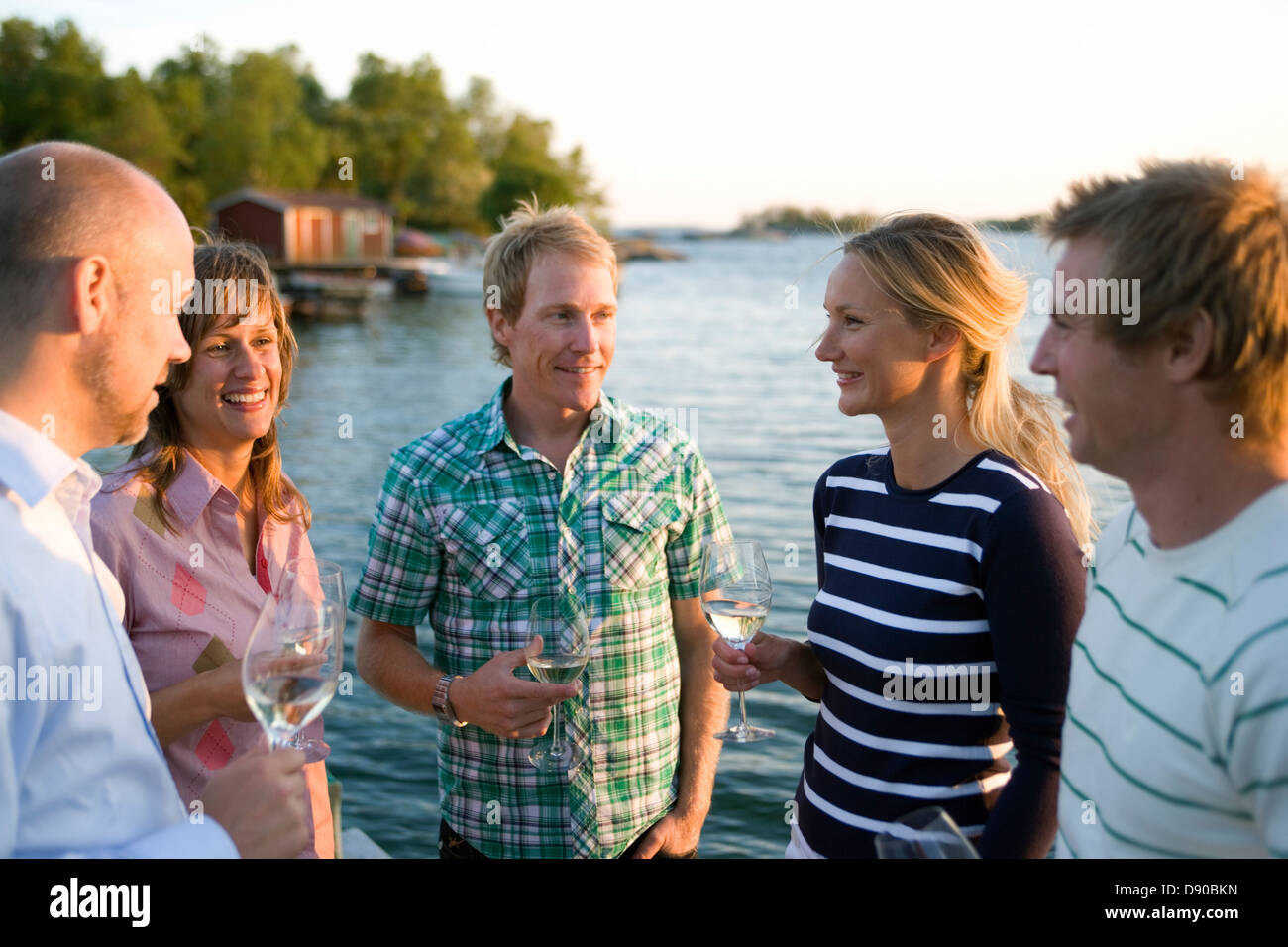 Fünf Freunde reden und trinken, Fejan, Stockholmer Schären, Schweden. Stockfoto
