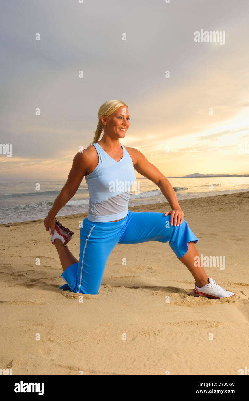 Eine blonde Frau tun stretching Übungen am Strand, Portugal. Stockfoto