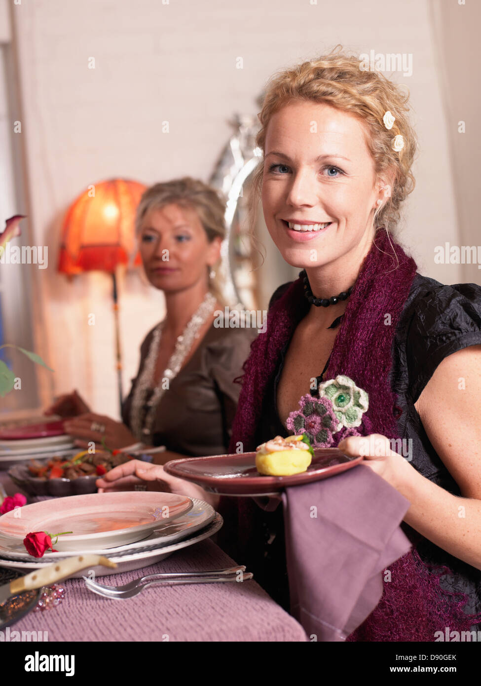 Frau mit Platte in der Nähe von Esstisch Stockfoto