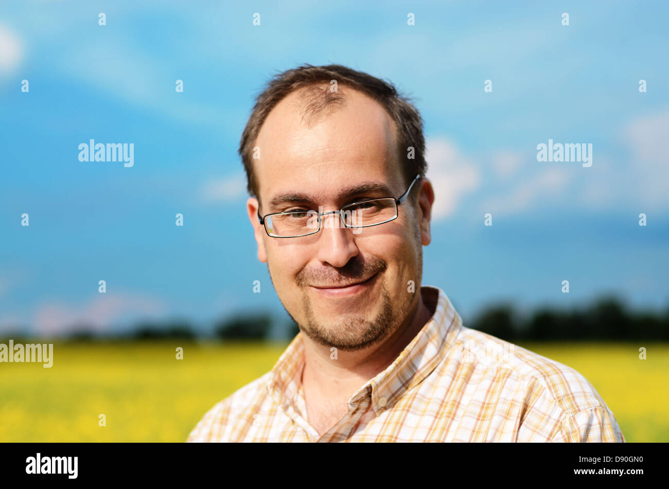 Erwachsener Mann im gelben Feld lächelnd Stockfoto