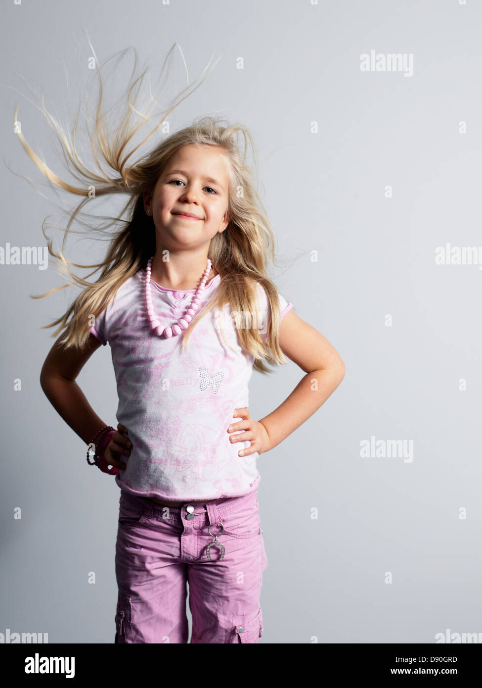 Lächelndes Mädchen mit der Hand auf den Hüften stehen Stockfoto