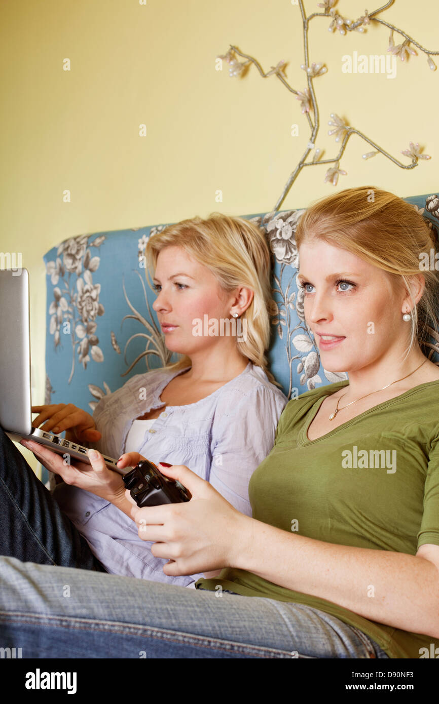 Zwei junge Frauen spielen Videospiel im Schlafzimmer Stockfoto