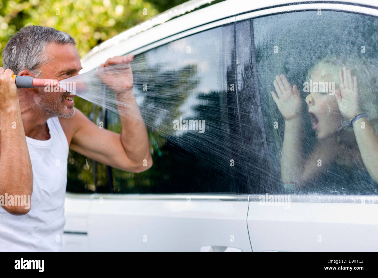 Auto waschen und spielen mit Tochter Vater Stockfoto