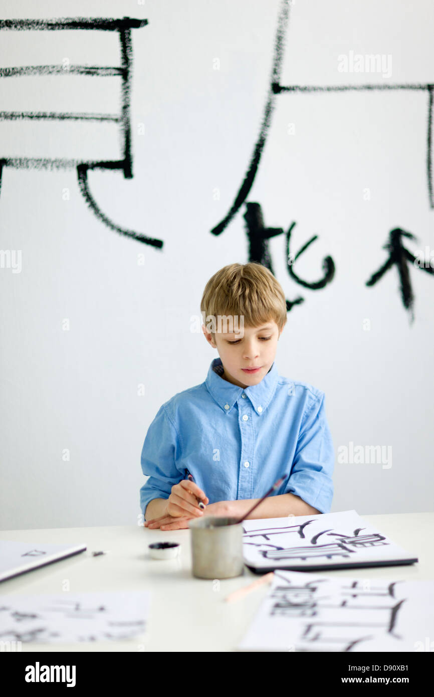 Junge und Caligraphing chinesischen Zeichen Stockfoto