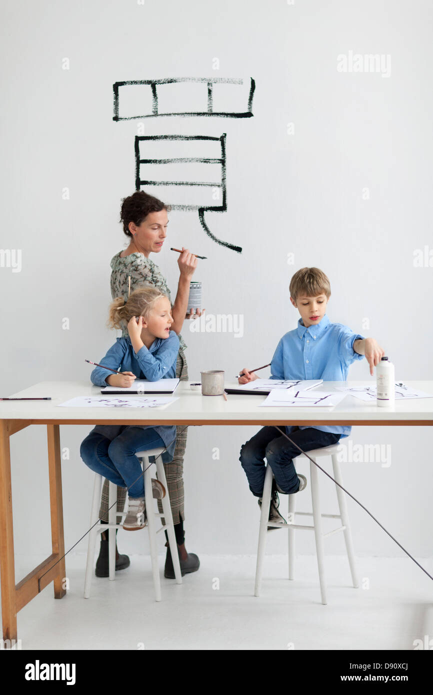 Junge, Mädchen und weibliche Lehrer Caligraphing Zeichen Chinesisch Stockfoto
