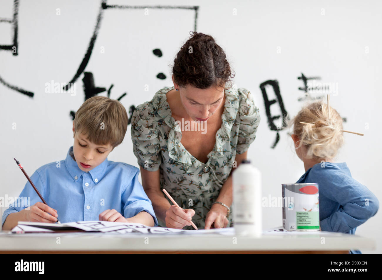 Junge, Mädchen und weibliche Lehrer Caligraphing Zeichen Chinesisch Stockfoto