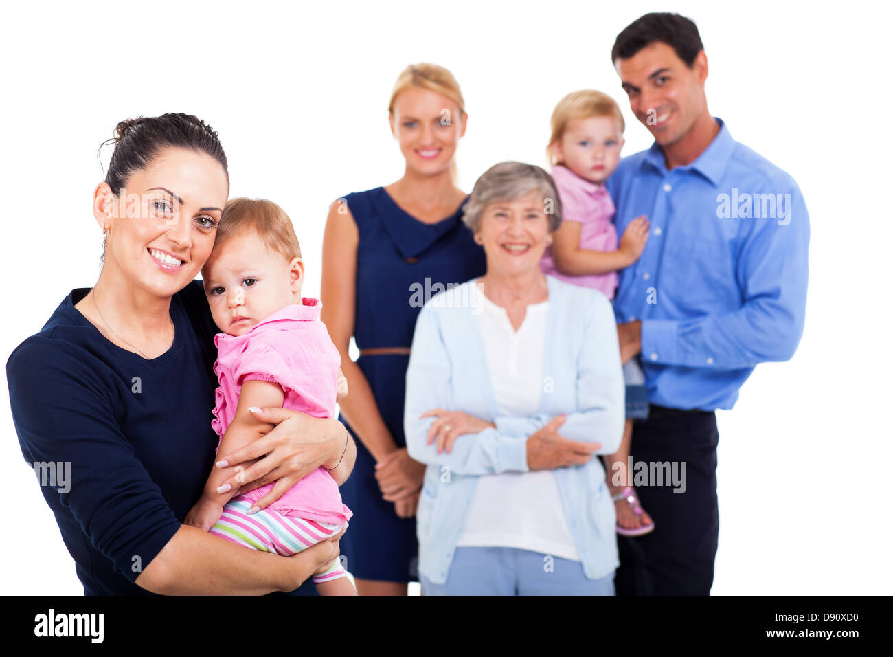 Porträt der jungen Frau hält ihr Baby mit Großfamilie auf Hintergrund Stockfoto