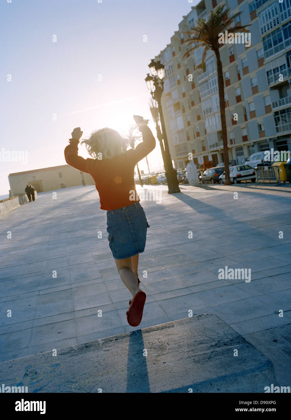Ein schwedisches Mädchen springen auf dem Bürgersteig, Spanien. Stockfoto