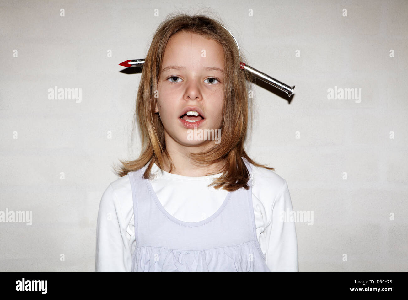 Mädchen mit gefälschten Nagel durch den Kopf, Studio gedreht Stockfoto