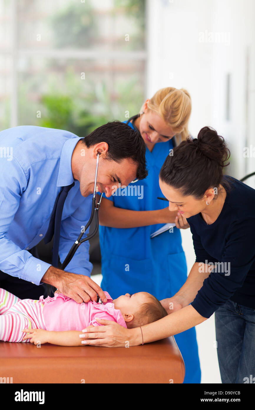fürsorgliche Ärztin untersucht ein krankes Babymädchen im Büro Stockfoto