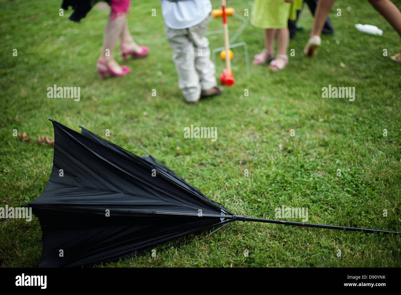 Beschädigten Sonnenschirm auf Rasen, Menschen im Hintergrund Stockfoto