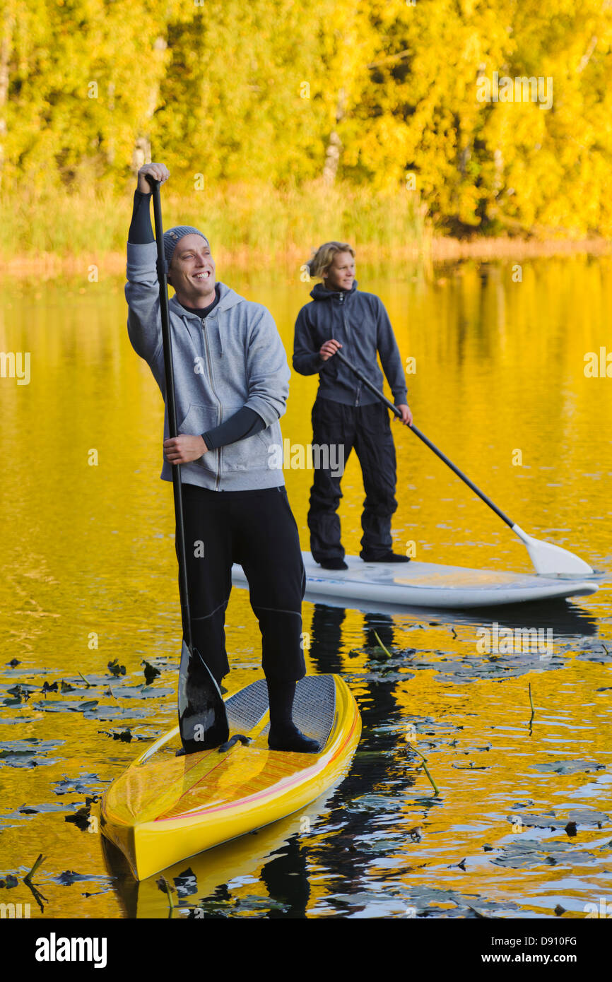 Zwei Menschen lächelnd auf Paddel-im Herbst Bäume Stockfoto