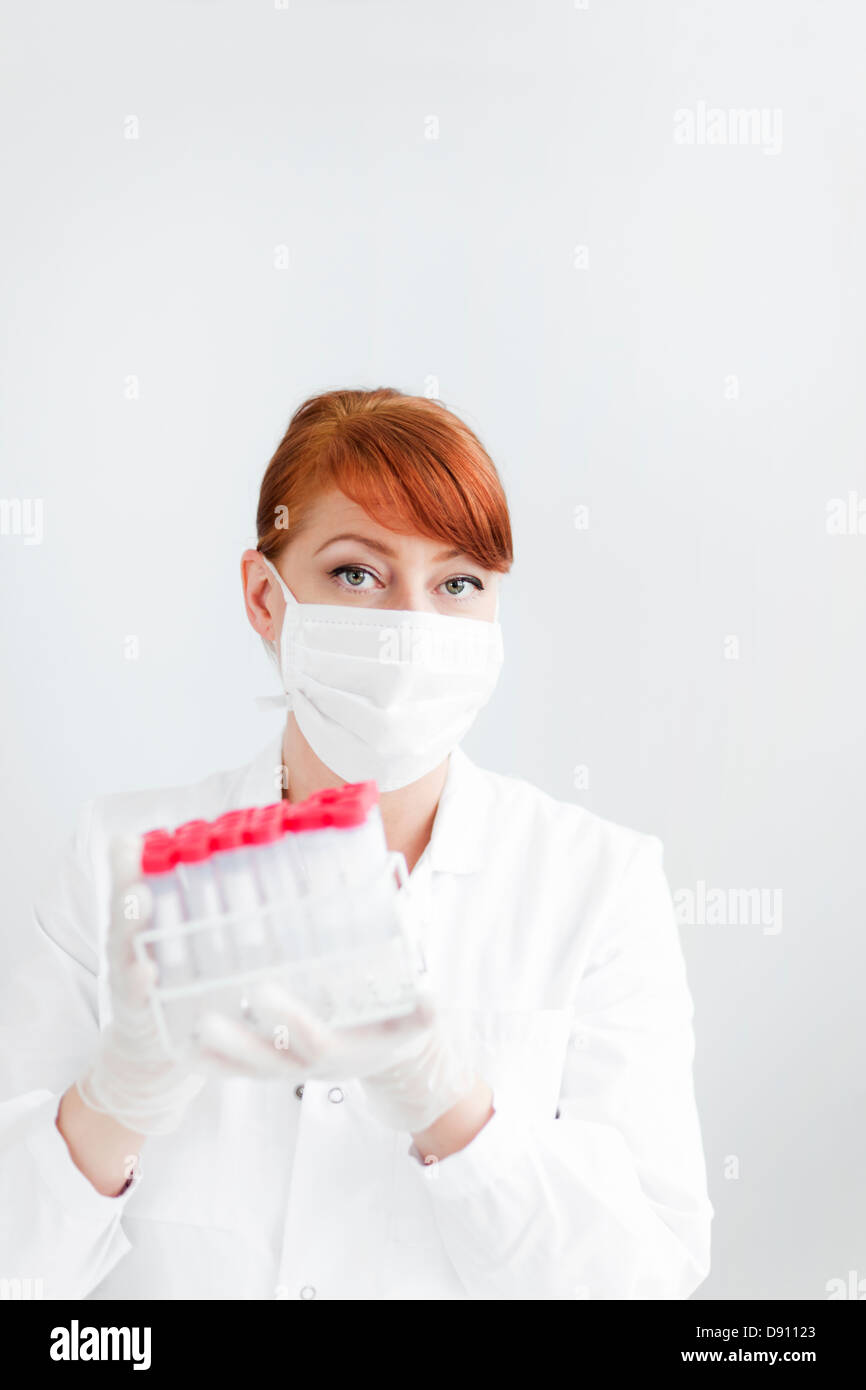 Wissenschaftlerin im Labor hält Reagenzgläser Stockfoto