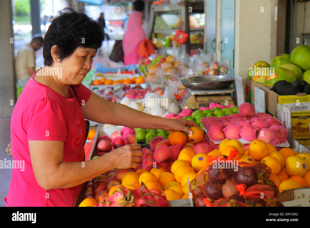 Singapur, Kallang Road, produzieren Stand, Früchte, Orangen, asiatische Frau weibliche Frauen, Shopping Shopper Shopper Shop Geschäfte Markt Märkte Markt kaufen se Stockfoto