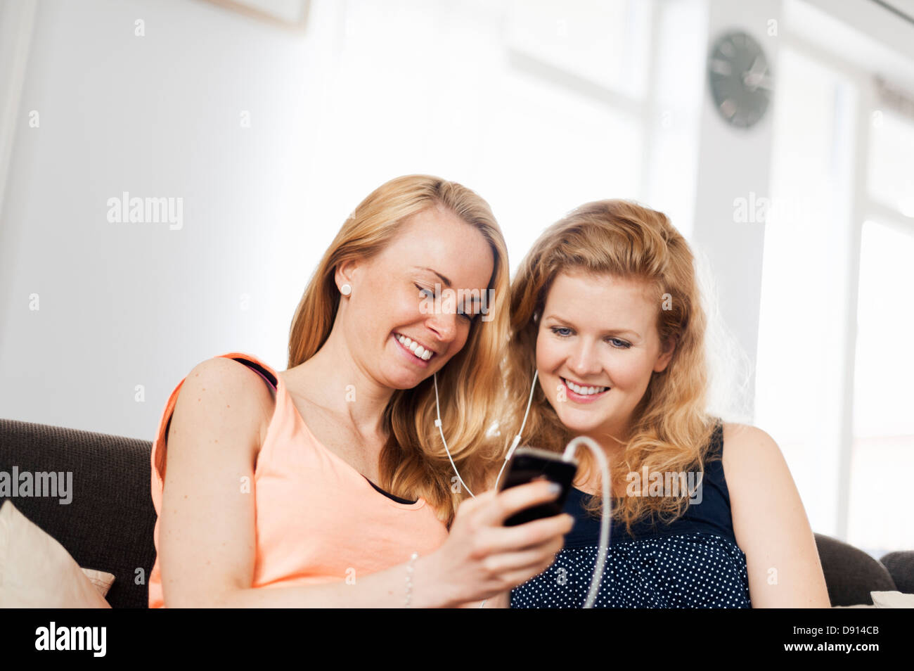 Zwei junge Frauen, die gemeinsam Musik hören Stockfoto