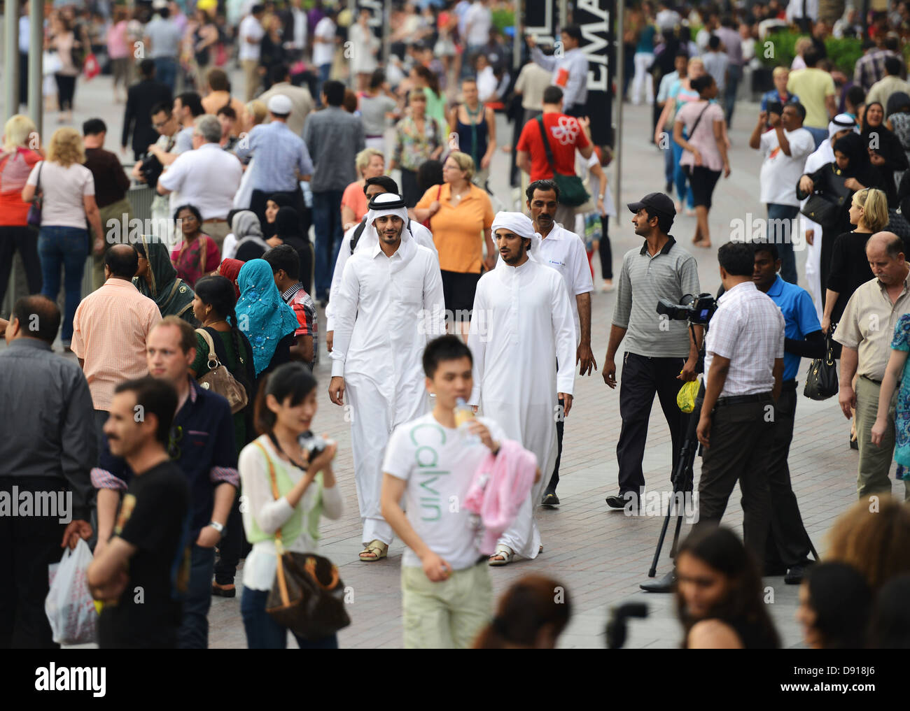 Arabische Männer in eine Menge von Touristen, Dubai, Vereinigte Arabische Emirate Stockfoto