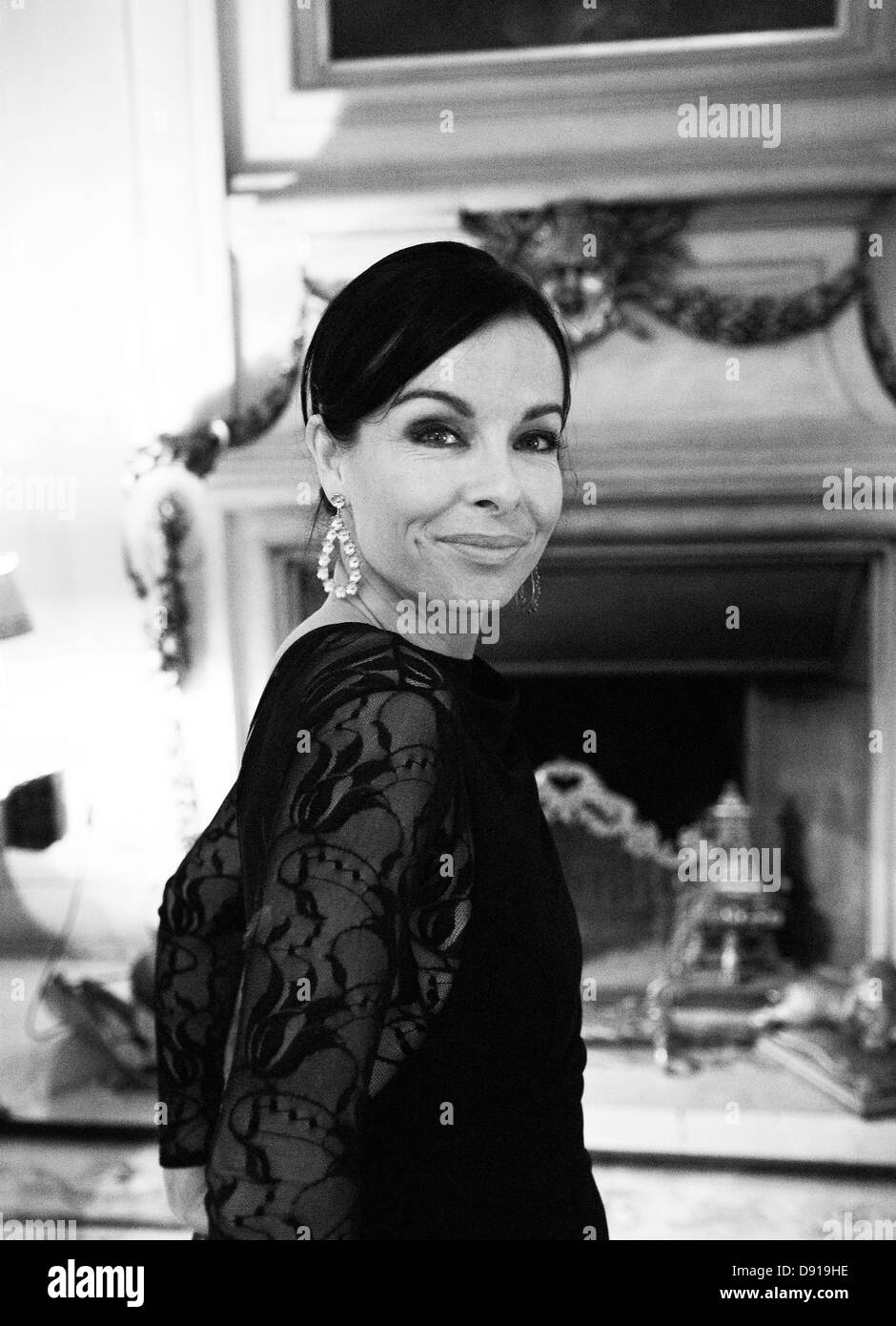 Eine lächelnde Frau stand vor einem Kamin. Stockfoto