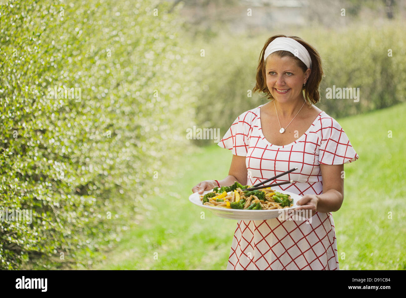 Eine Frau hält einen Teller Pasta, Schweden. Stockfoto