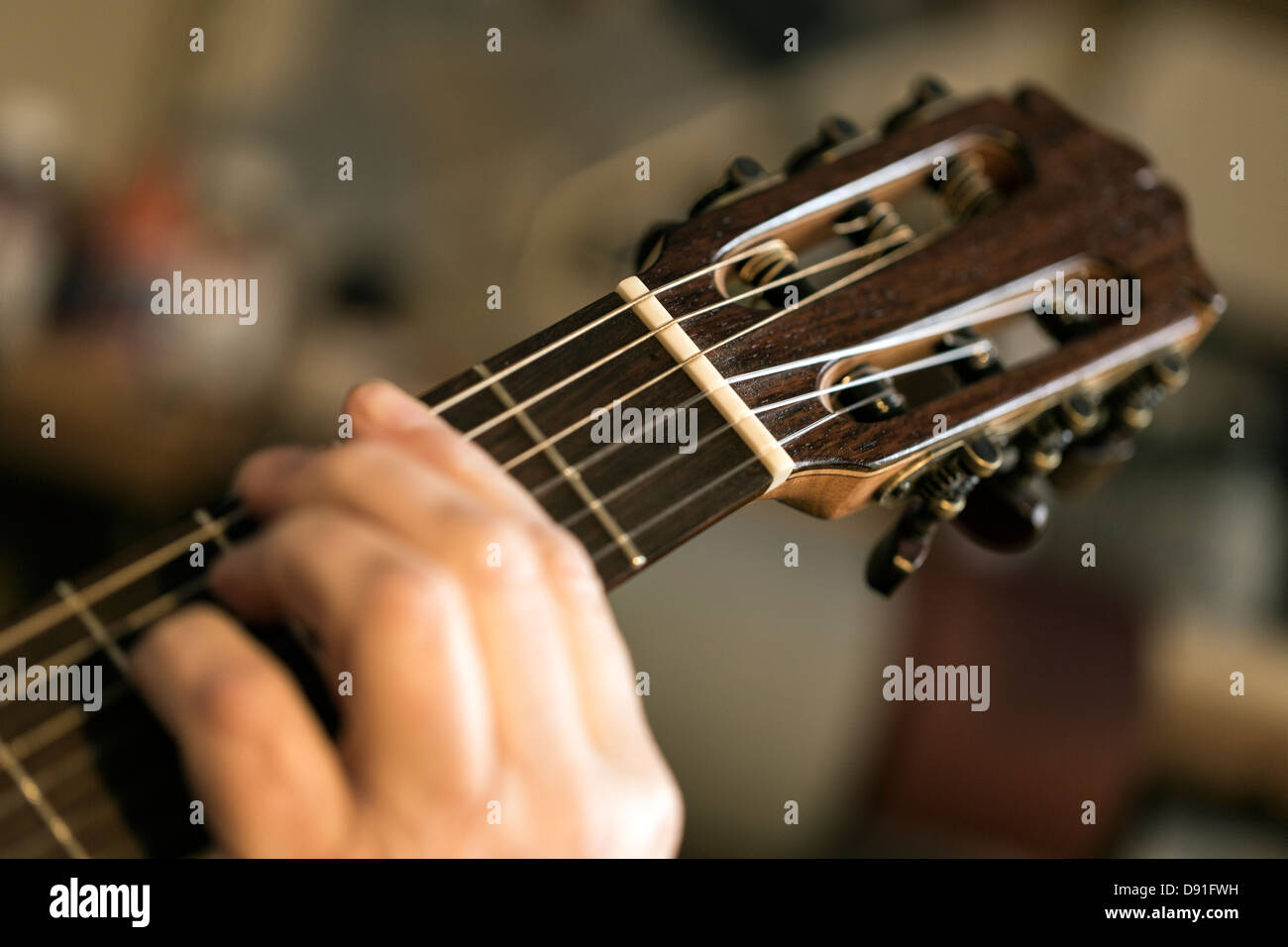 Nahaufnahme von Gitarrenbauer tuning und testen Akustikgitarre in Werkstatt Stockfoto