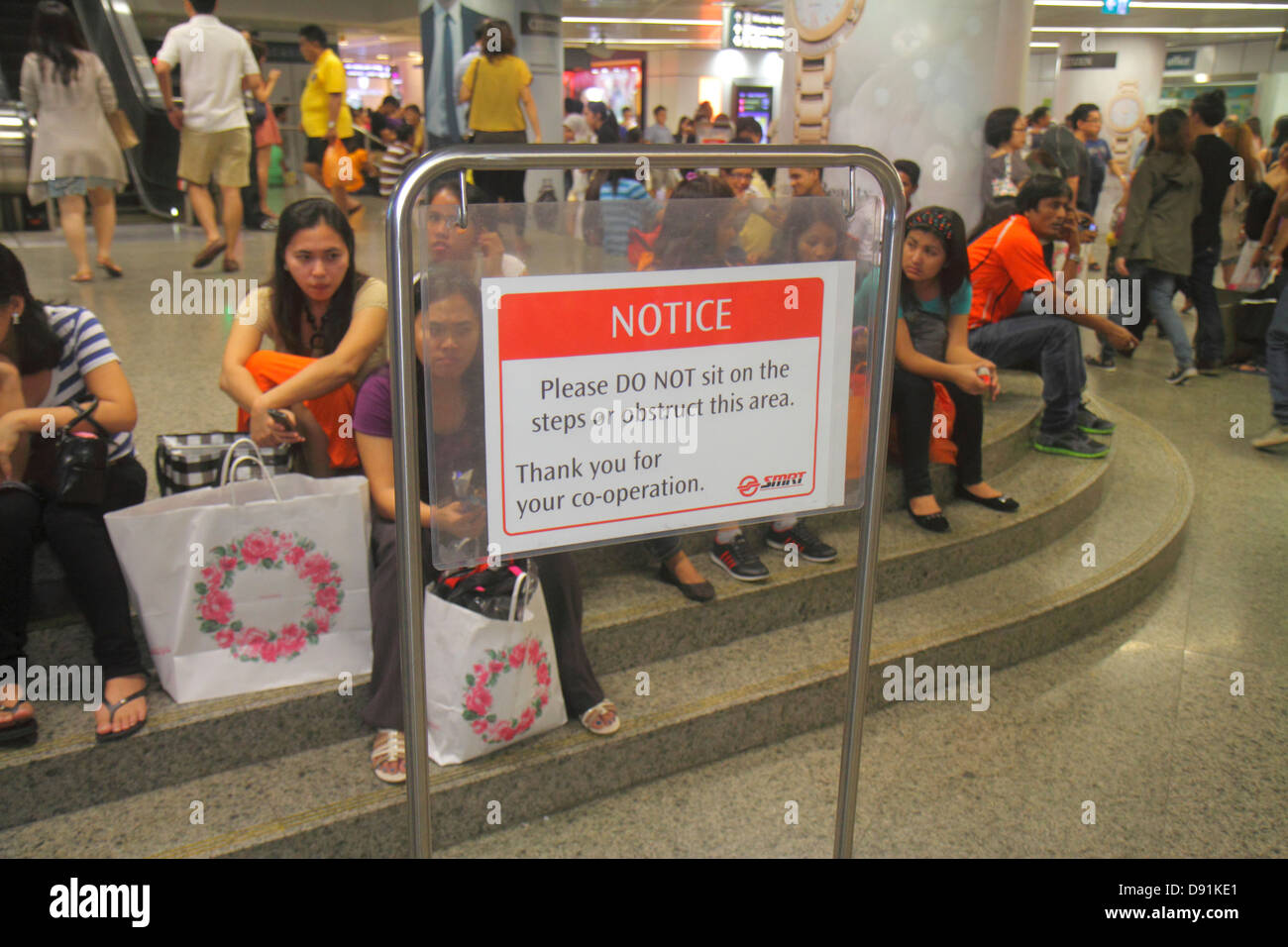 Singapur, Orchard MRT-Station, Nord-Süd-Linie, U-Bahn-Zug, Fahrer, Pendler, Zeichen, bemerken, nicht, ignoriert werden, Regeln brechen, verletzen, asiatische Frau FEM Stockfoto